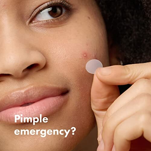 Woman applying a pimple patch to her face.